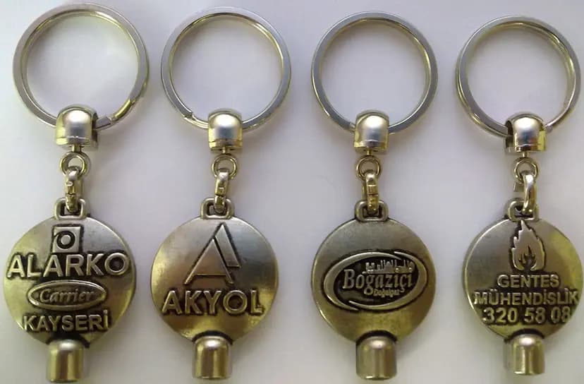 promosyon dört altın renkli metal anahtarlık, yuvarlak gövde, üstte halka, altta silindir uç