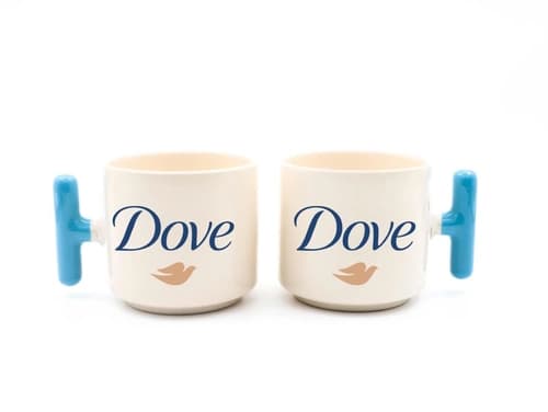 Mavi kulplu beyaz porselen promosyon latte fincanı ikili; önde kuş figürlü logo baskısı