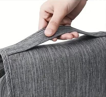 Gri çizgili çantanın üst sapı bir el tarafından kaldırılıyor.
